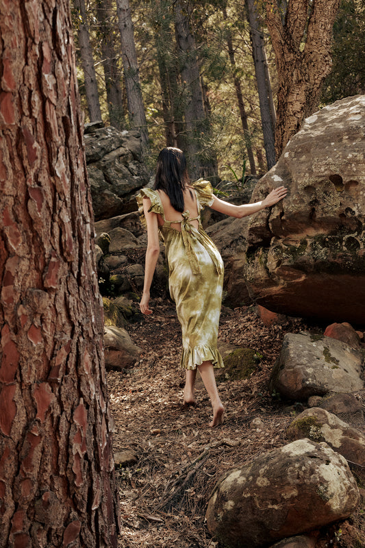 Model in the forest wearing the Museā Poppy Dress, crushed dyed in olive.