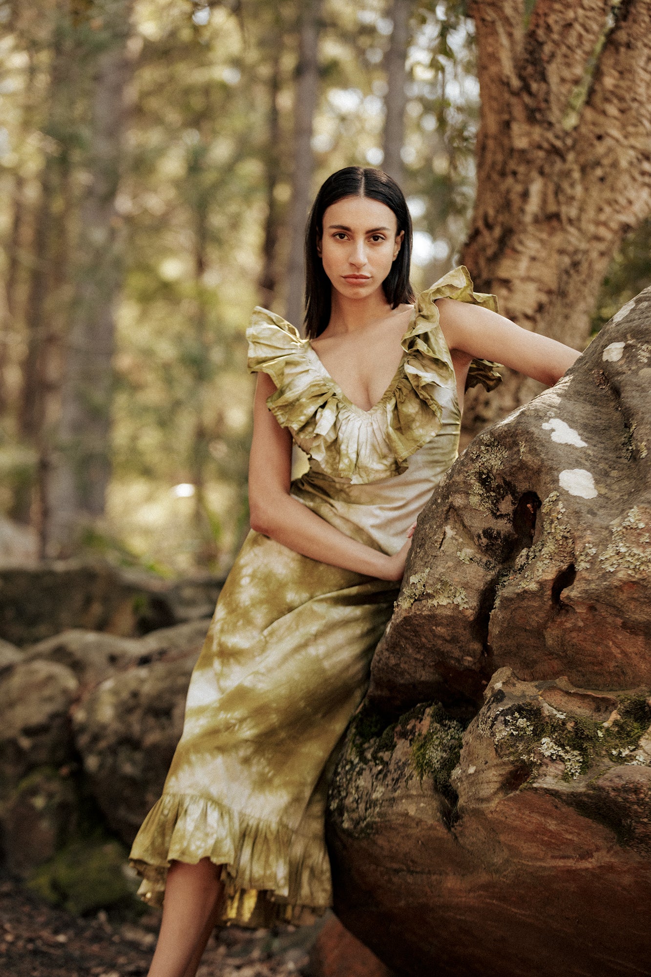 Model in the forest wearing the Museā Poppy Dress, crushed dyed in olive.