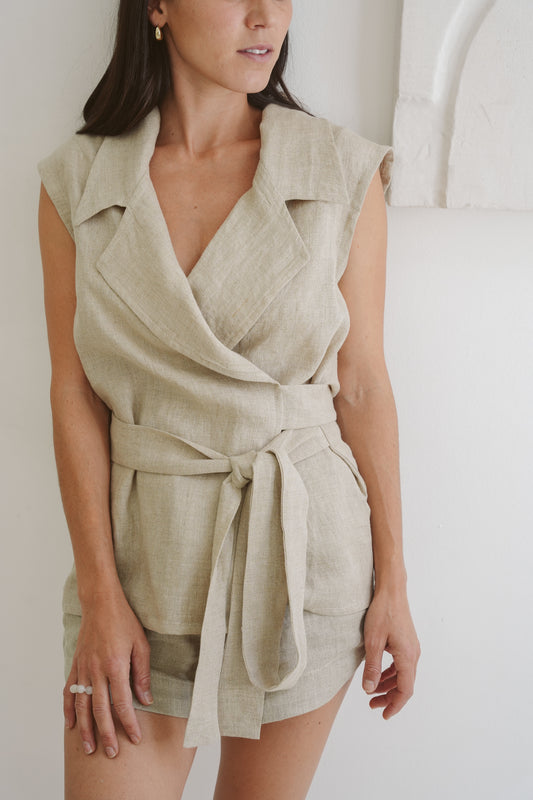 Model presents the belt detail on her Museå linen collared waistcoat