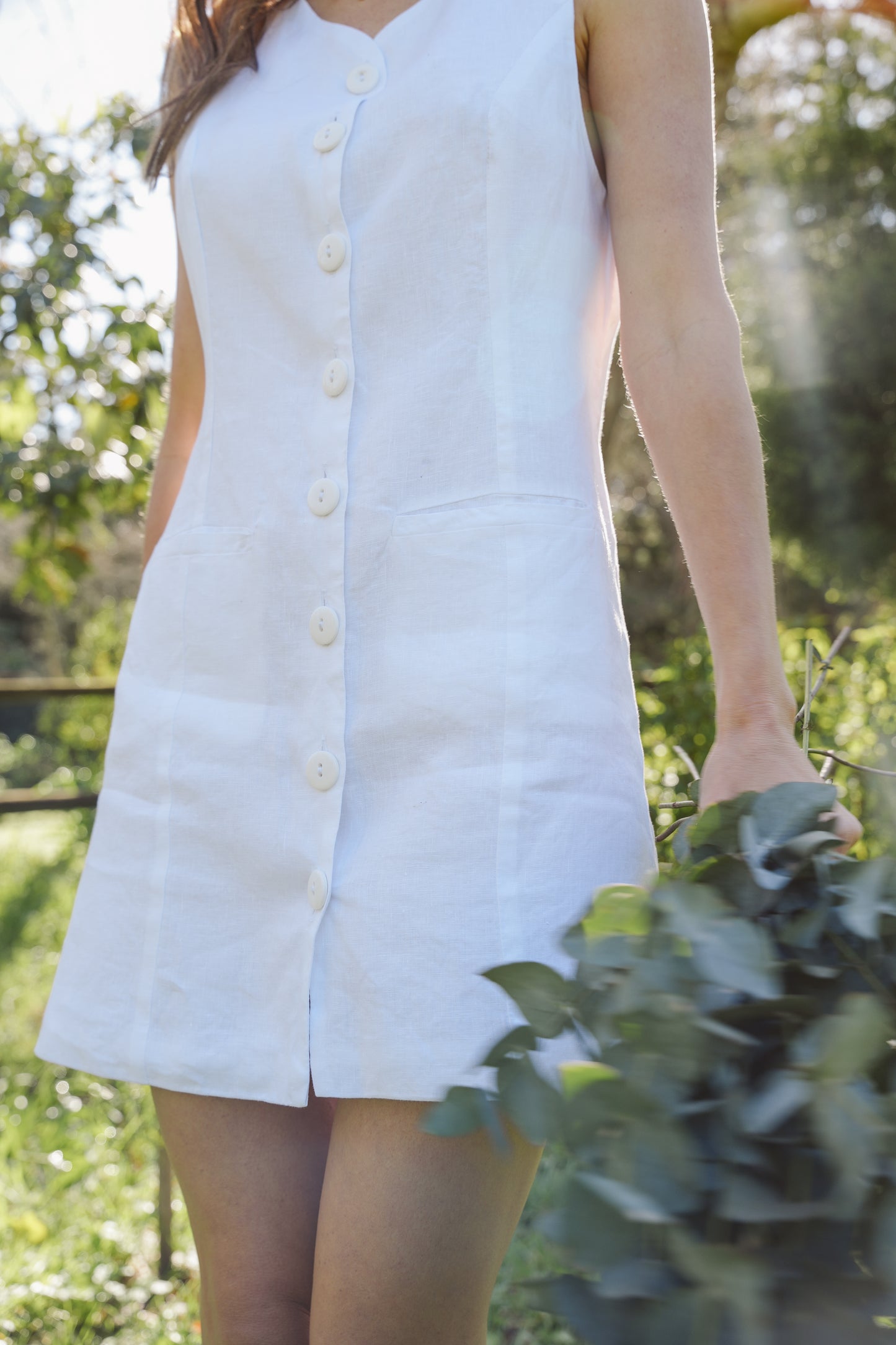 White linen shift dress worn by a woman in an outdoor setting
