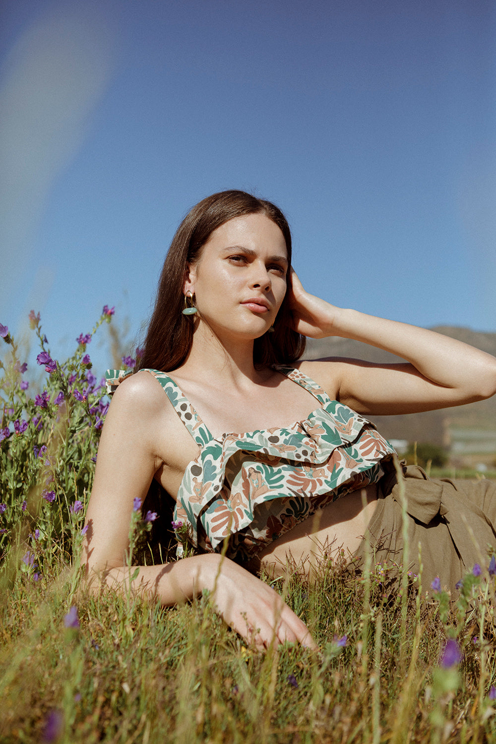 Model lying in the field wearing the Ella bandeau