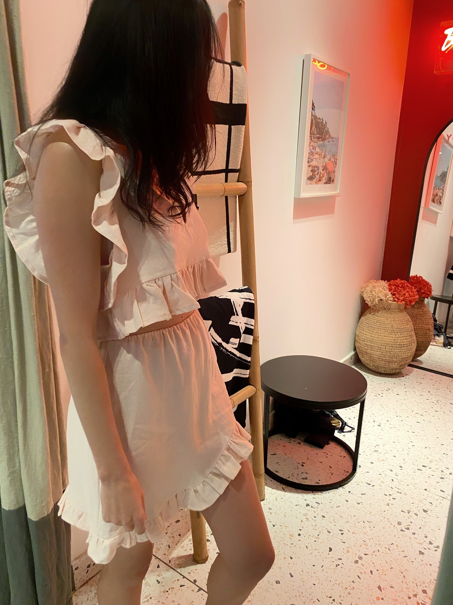 Model wearing frilly top and skirt in blush pink