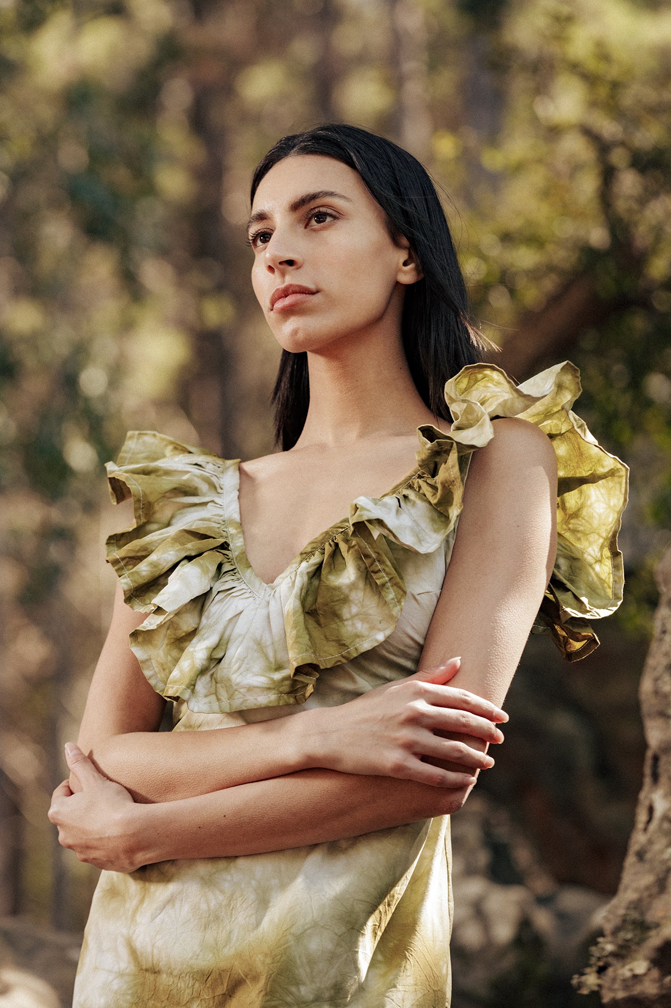 Model in the forest wearing the Museā Poppy Dress, crushed dyed in olive.