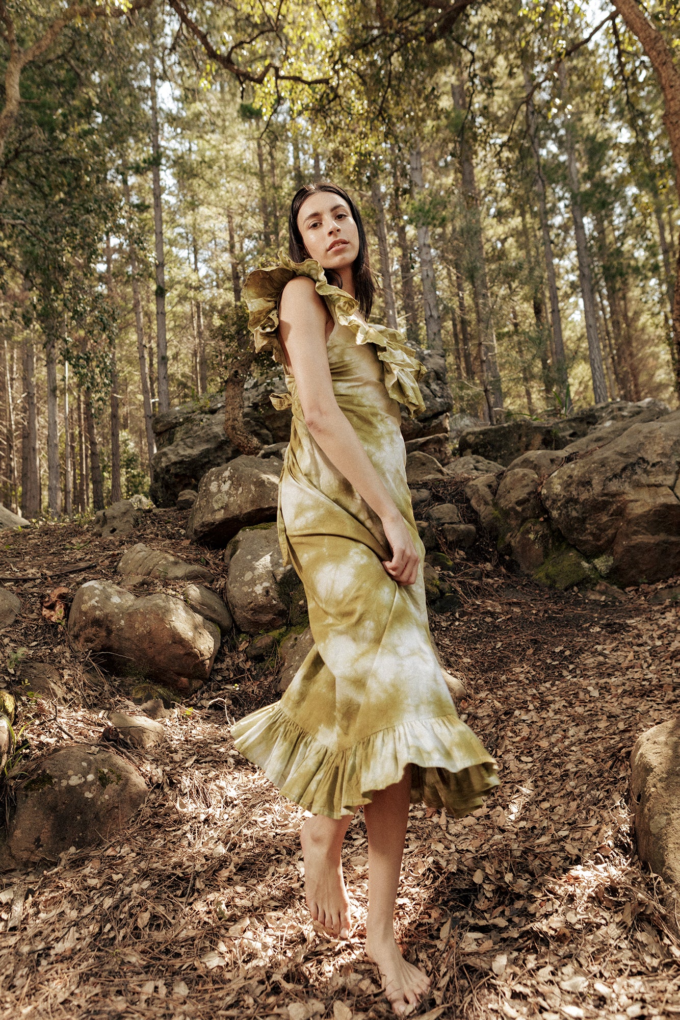 Model in the forest wearing the Museā Poppy Dress, crushed dyed in olive.