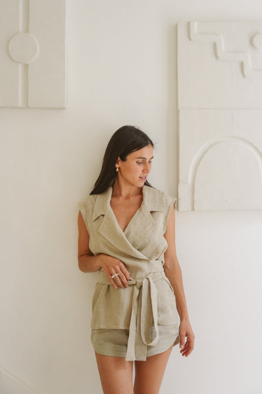 Model posing against a wall backdrop wearing our linen Museā waistcoat with collar