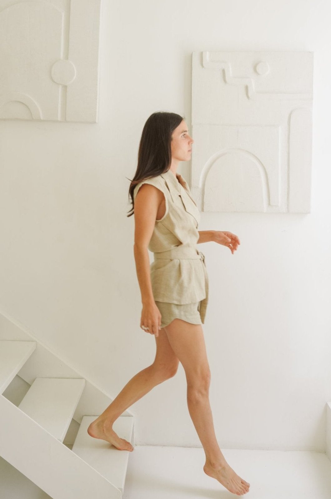 Model walking down the stairs while wearing linen collared waistcoat