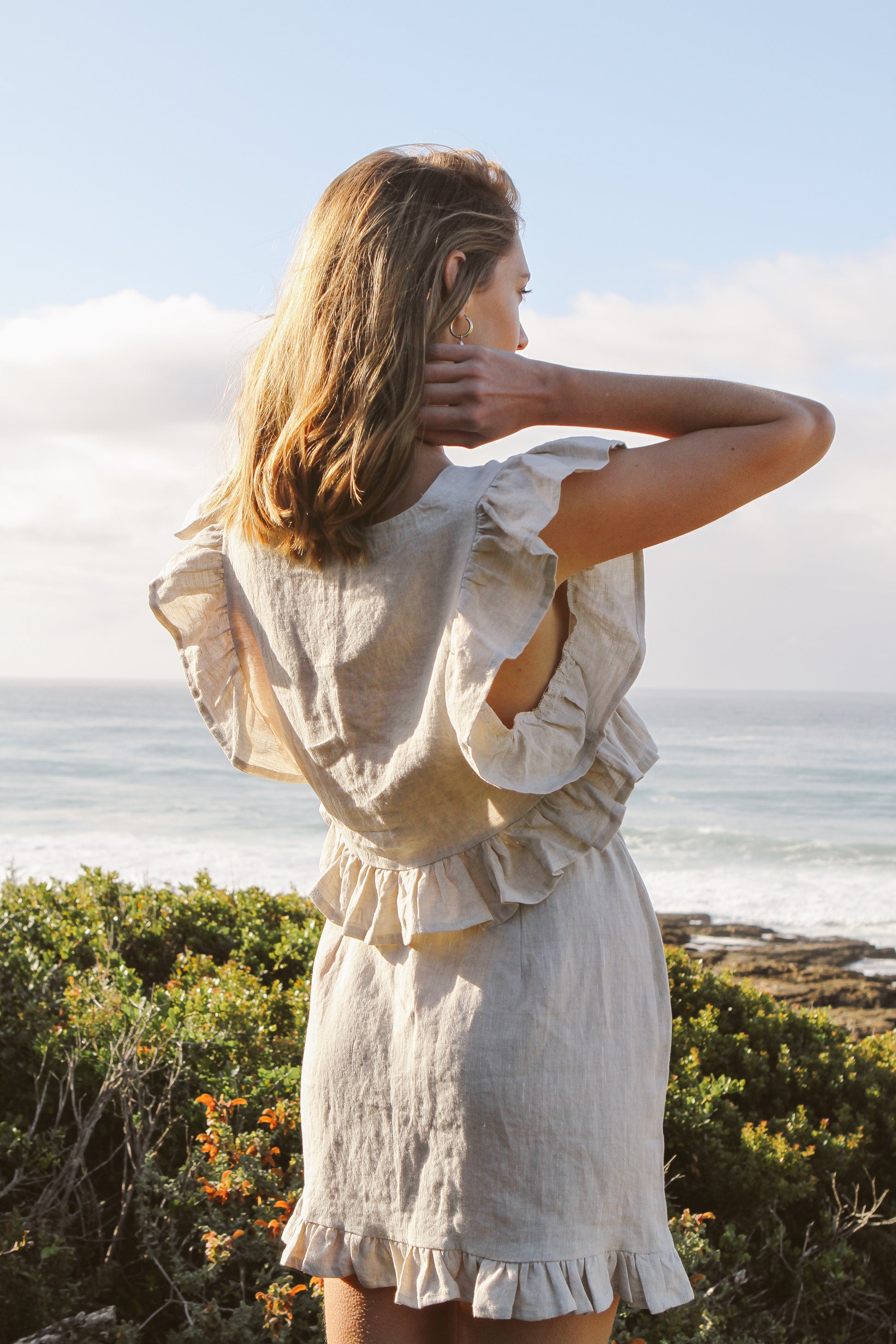 Model wearing frilly linen top and frilly linen skirt.