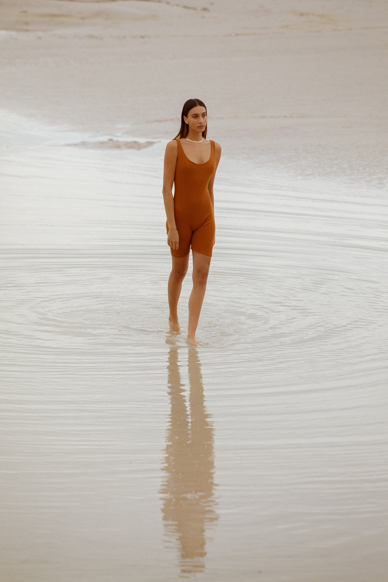 model wearing bronze bodysuit